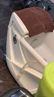 An extension cord taped to a pedi chair. They plug in an electric mixer & sand your foot over the bath. Electricity + water = not safe.