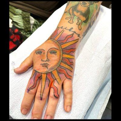 Sun hand tattoo by Cari @carebeartattoos at Wolf & Shadow Tattoo Collective