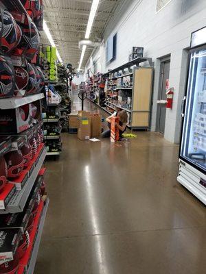 Aisle blocked by employee next to fire exits.