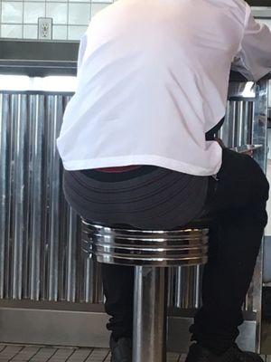 Employee sitting in front of us with his ass hanging out