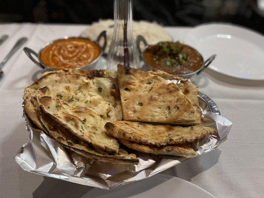 Garlic Naan (left) and Paneer Chili Naan (right); Butter Chicken and Goat Curry in the back