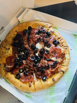 Small personal pizza with pepperoni, bacon and olives