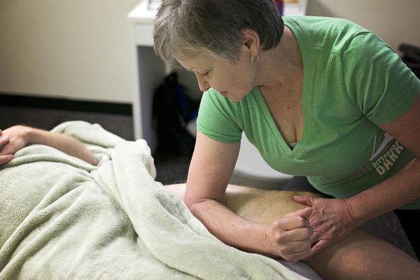 Massage therapist, Claudia Griffin, helping a client recover from a workout.