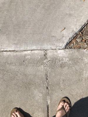 Concrete in sidewalk where my feet are.