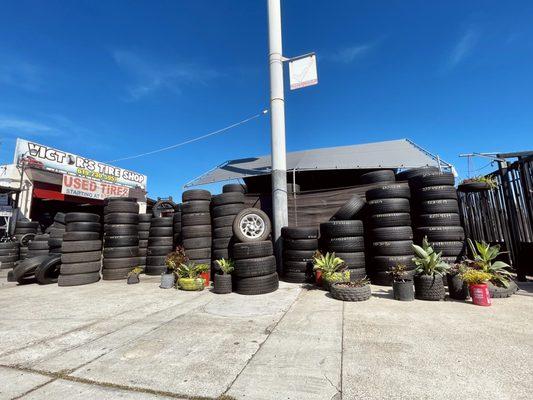 Tires and plants inside of recycled tires and the shop sign.