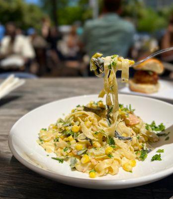 Handmade summer fettuccini with smoked salmon, spring onions and corn crema