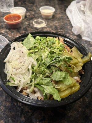 Chicken shawarma bowl with lettuce, pickles, and onions