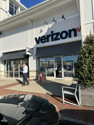 Man lighting a cigarette at 10am at Wireless Zone at Derby Shops in Hingham