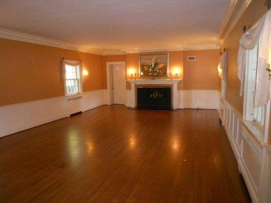 Huge open ballroom with giant original fireplace. Beautiful custom woodwork!