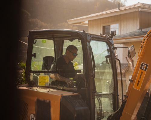 Kana'i operating a CAT vehicle on a construction site.