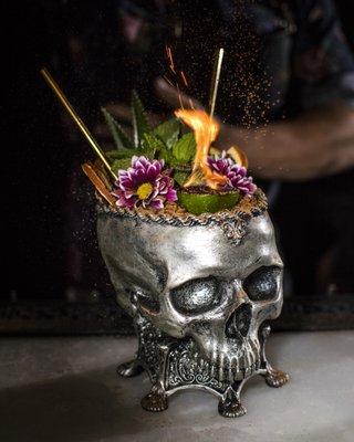 ZOMBIE
 rr tiki rum blend, donn's mix, falernum, lime,
 grenadine, angostura, flamed absinthe, served in a skull with flamed cinnamon powder