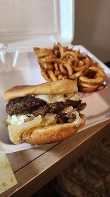 Mushroom Swiss burger with curly fries.