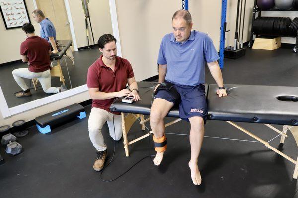 physical therapist helping patient with leg pain