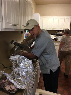 Carving smoked turkey for "In His Name Thanksgiving Feast."