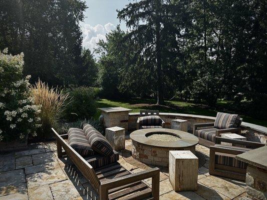 Elegant fire pit surrounded by a beautifully manicured lawn.