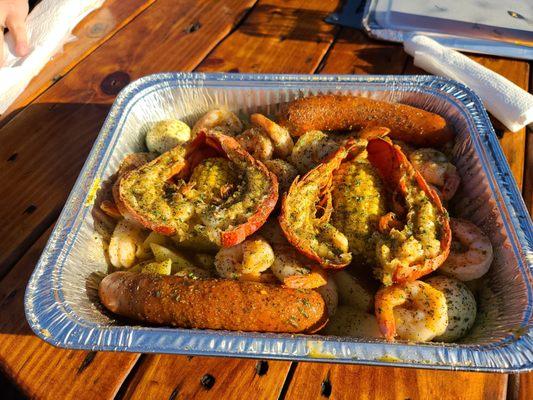 Lobster, Shrimp, eggs, sausage, corn of the cob, and potatoes served in butter. More than enough for two people.