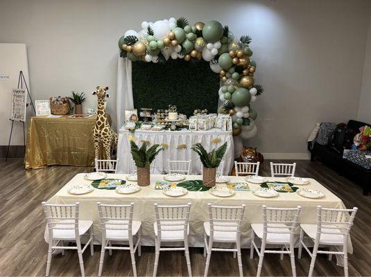 Beautiful balloon garland, backdrop, tables, chairs, themed plates, and white tablecloths provided by Wigglin' Out