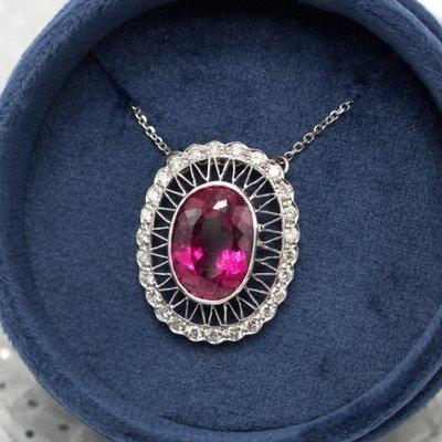 A luscious 7.25 carat pink tourmaline surrounded by diamonds in a white gold filigree pendant.