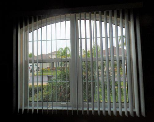 Vertical Blinds over an arched window.