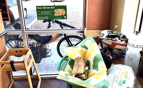 Interior view of my delicious brekkie sub, Skid-lid, water bottle with my eBikeKit-assisted CruzBike parked outside.