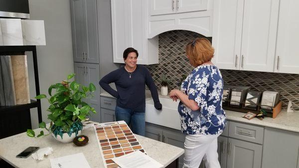 Owner Amie helps a customer match tile to her cabinets.