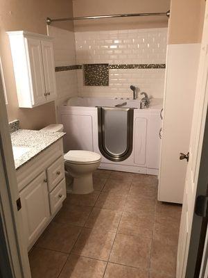 New vanity, cabinets and walk in tub with custom subway tile surround