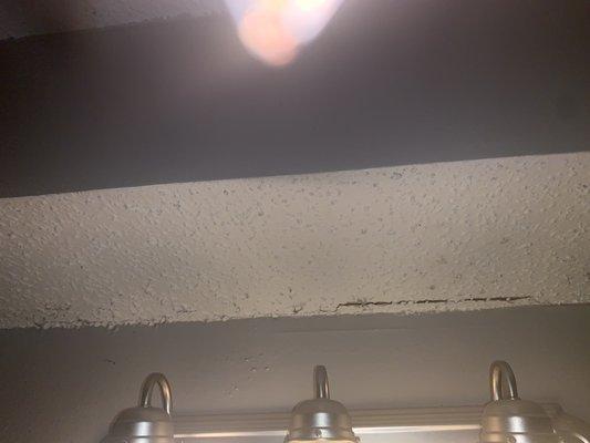 The water damage and crack above sink