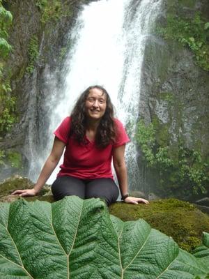 Chief Editor and Bottle Washer Elizabeth (Betsy) Herman with friends, leaf, rock and waterfall in Costa Rica.