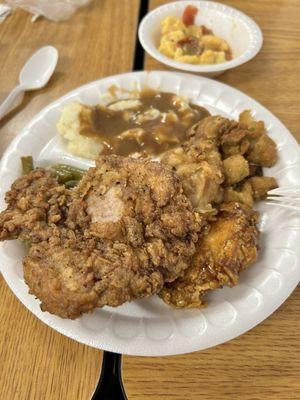 Mashed potatoes, green beans, fried pork, chop, macaroni and cheese with stewed tomatoes and okra