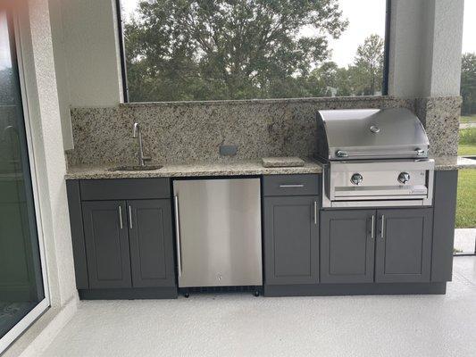 Outdoor kitchen with granite countertop, backsplash and windowsill by All Granite.