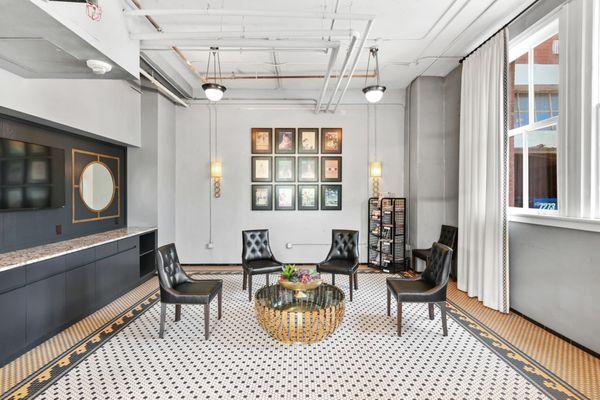 Vintage lounge area with black chairs, mosaic flooring, an artistic coffee table and natural lighting at South Side on Lamar