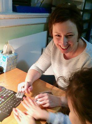 Julia Litsina, OTR engages with child in power putty activity