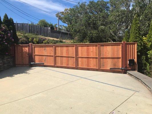 Metal fabricated mechanical double swing drive gate and pedestrian gate with redwood cladding