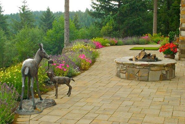 A fire pit, some art, a fabulous view, framed by a lovely planting bed.