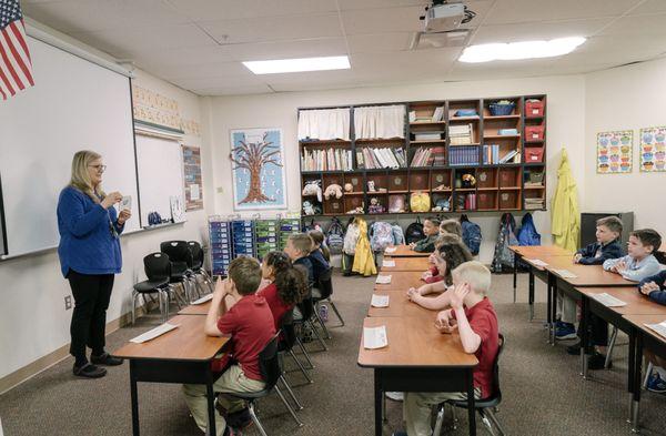 Children sitting in class listening to their teacher