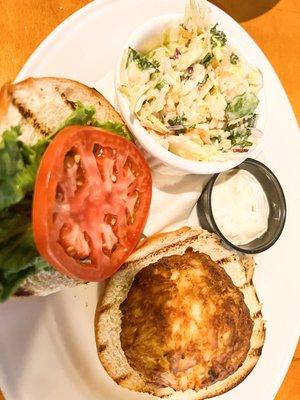 Crab cake sandwich with side of coleslaw with brussels sprouts