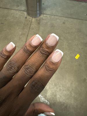 Uneven lines and blotchy paint. I asked her multiple times to fix the lines and she wouldn't. These nails are 2 days old.