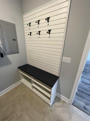 Laundry room peg board and bench with shoe shelves underneath