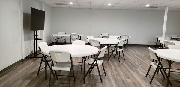 Event room with chairsn tables, TV for presentations.