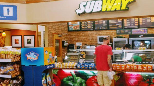 closer up you of the counter and kiosk. directly under the bathroom signs is a little dining area for Subway