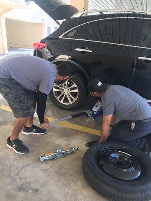 My husband and neighbor fixing my flat the morning after I got my flat "fixed" at Chris Tire Shop. NEVER AGAIN