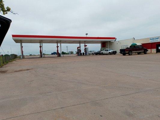 Large parking lot. This is the side of the gas station. Back road attached going into town or the highway crossing.