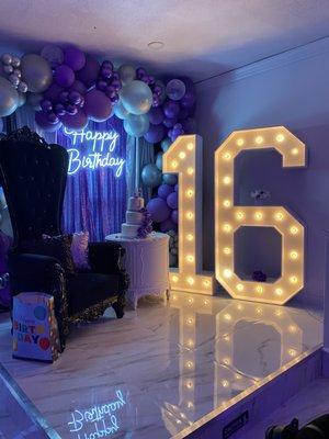 Balloon and drape backdrop wall with 6-foot tall lighted numbers and Black Tiffany throne chair.