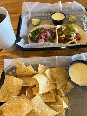 Barbacoa taco with pickled onion and beef taco with jalepenos. Side of chips n queso