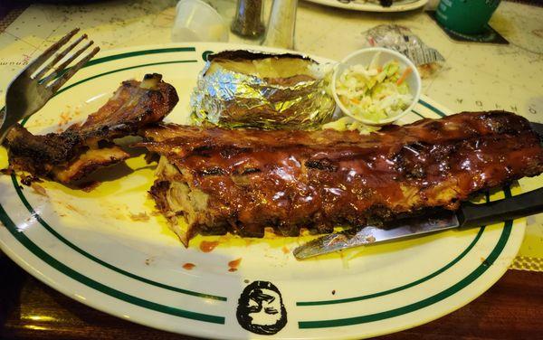 The baby back ribs full rack with a baked potato.