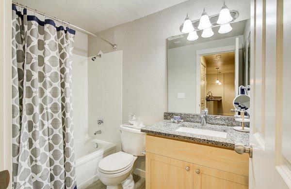 Staged bathroom featuring granite countertops.