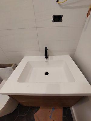 Installing the sink and faucet in the bathtub.