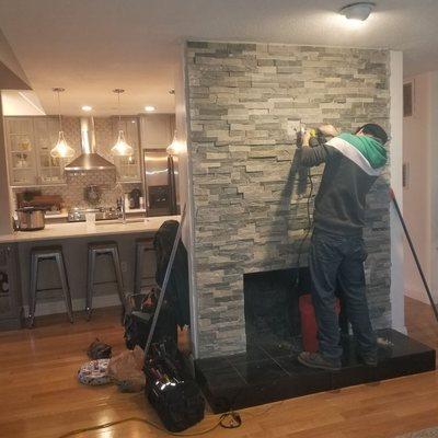 Installation of tv box in stone wall above fireplace.