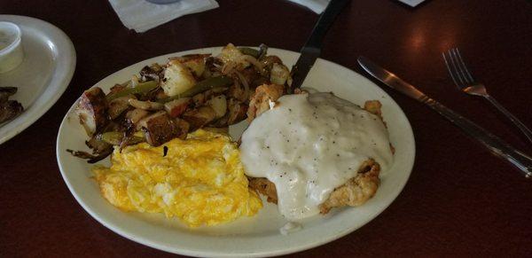 Chicken fried steak breakfast with home fries.