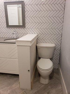 built half wall with pull out shelves to hide toilet.